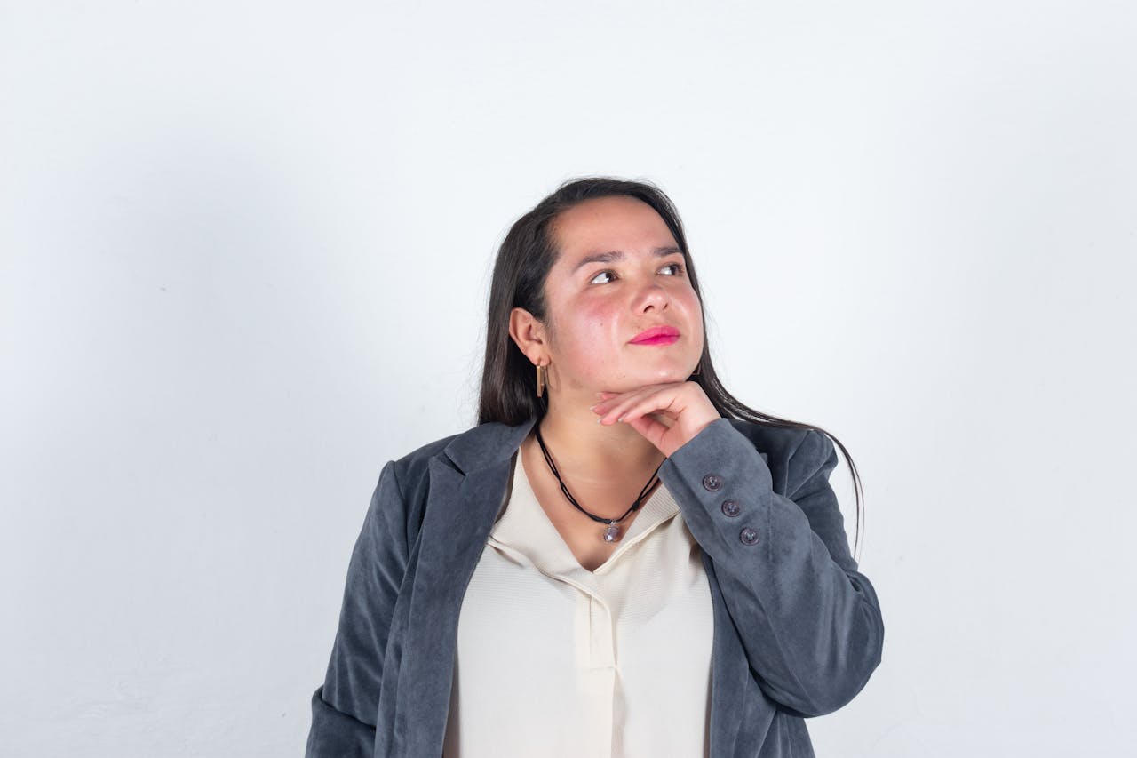 Crafting Captivating Headlines: Your awesome post title goes here A confident businesswoman in a gray blazer posed thoughtfully against a plain white background.